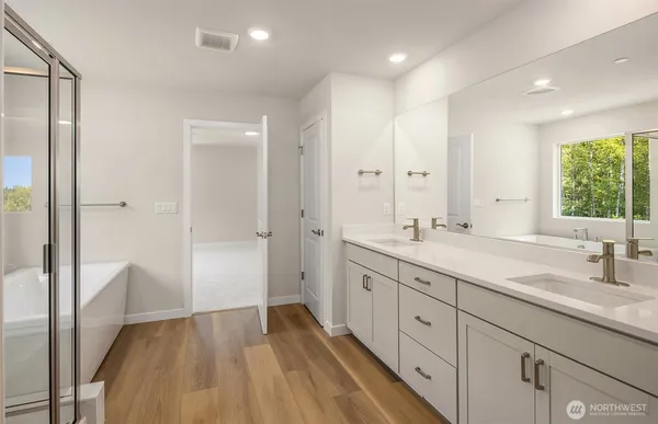 a spacious bathroom with a double vanity sink a mirror and a shower