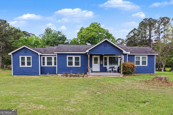 a front view of a house with yard and green space