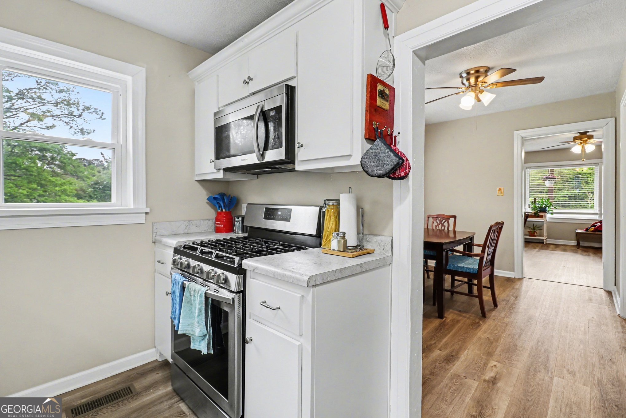 497 Corinth Road Hogansville, GA 30230 - Photo 12 of 37 a kitchen with stainless steel appliances granite countertop a stove top oven a sink dishwasher and white cabinets with wooden floor