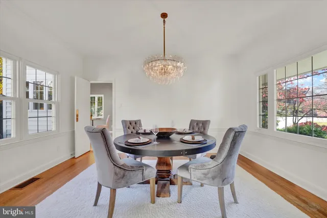a dining room with furniture a chandelier and wooden floor
