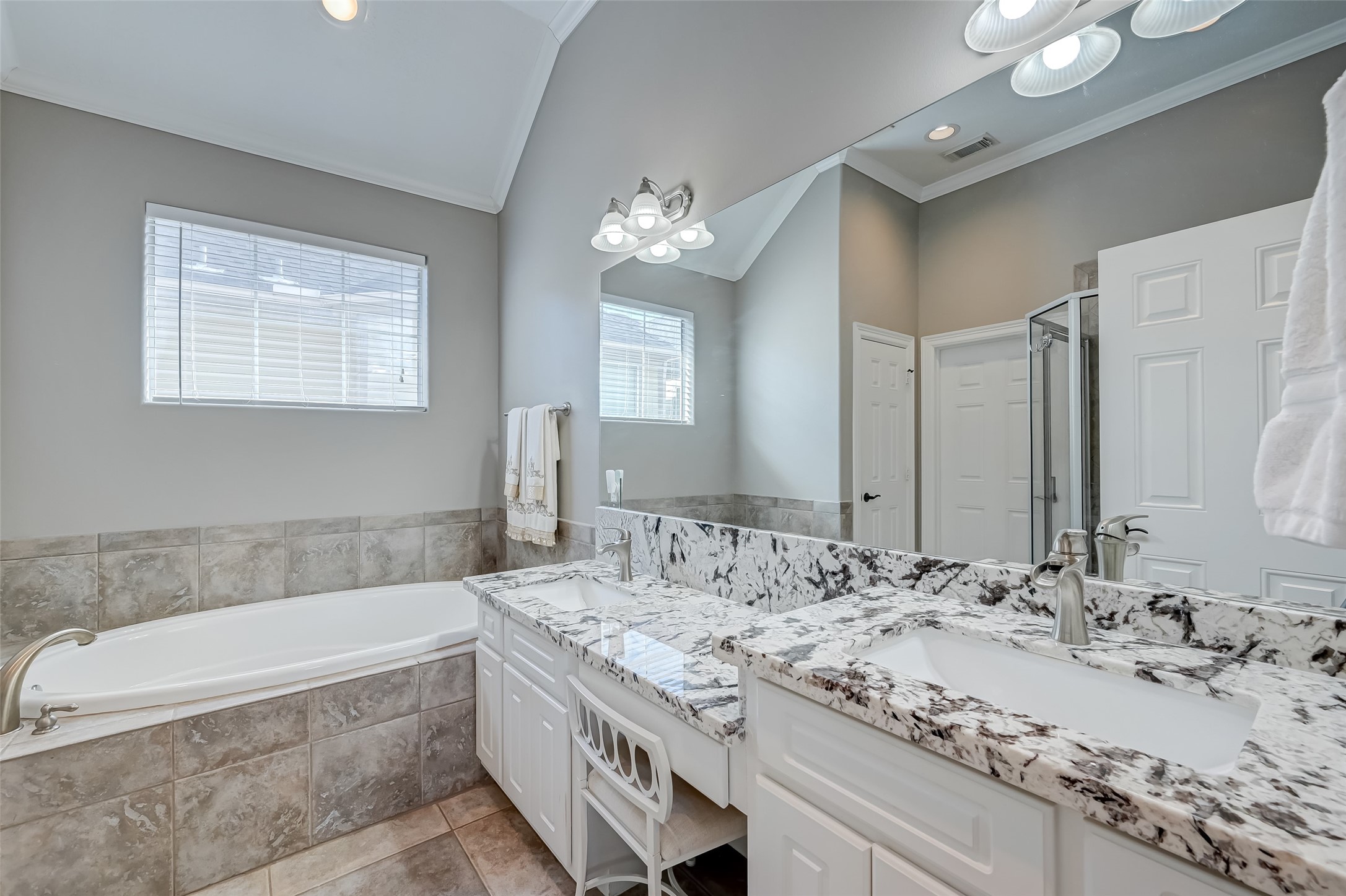 410 Fowler Street Houston, TX 77007 - Photo 24 of 49 a bathroom with a granite countertop bathtub a double vanity sink and a mirror