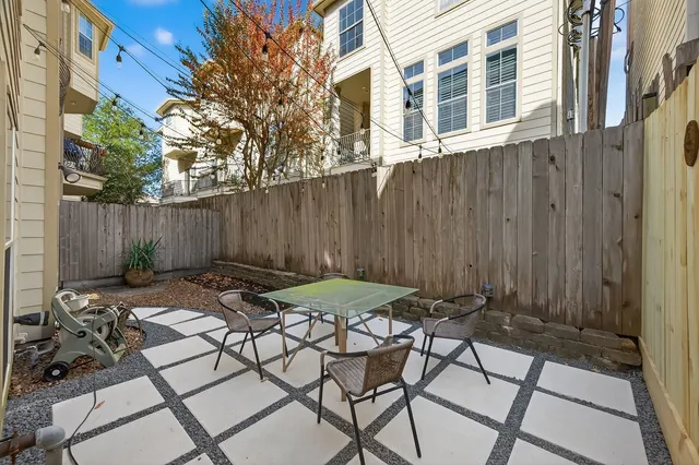 a view of a patio with table and chairs with wooden fence and plants