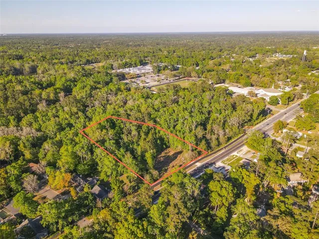 an aerial view of residential houses with outdoor space and trees