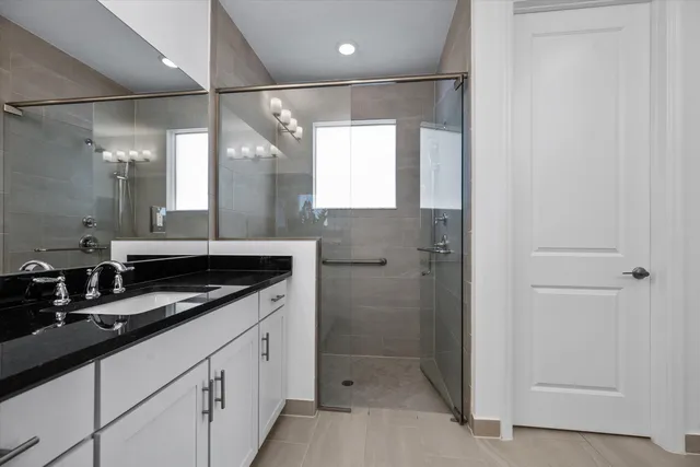 a bathroom with a double sink shower and a mirror