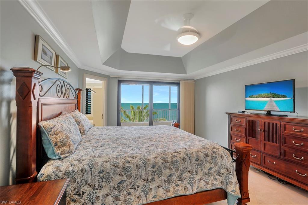 623 La Peninsula Boulevard, Unit 623 Naples, FL 34113 - Photo 18 of 27 a bedroom with a bed and a dresser with mirror