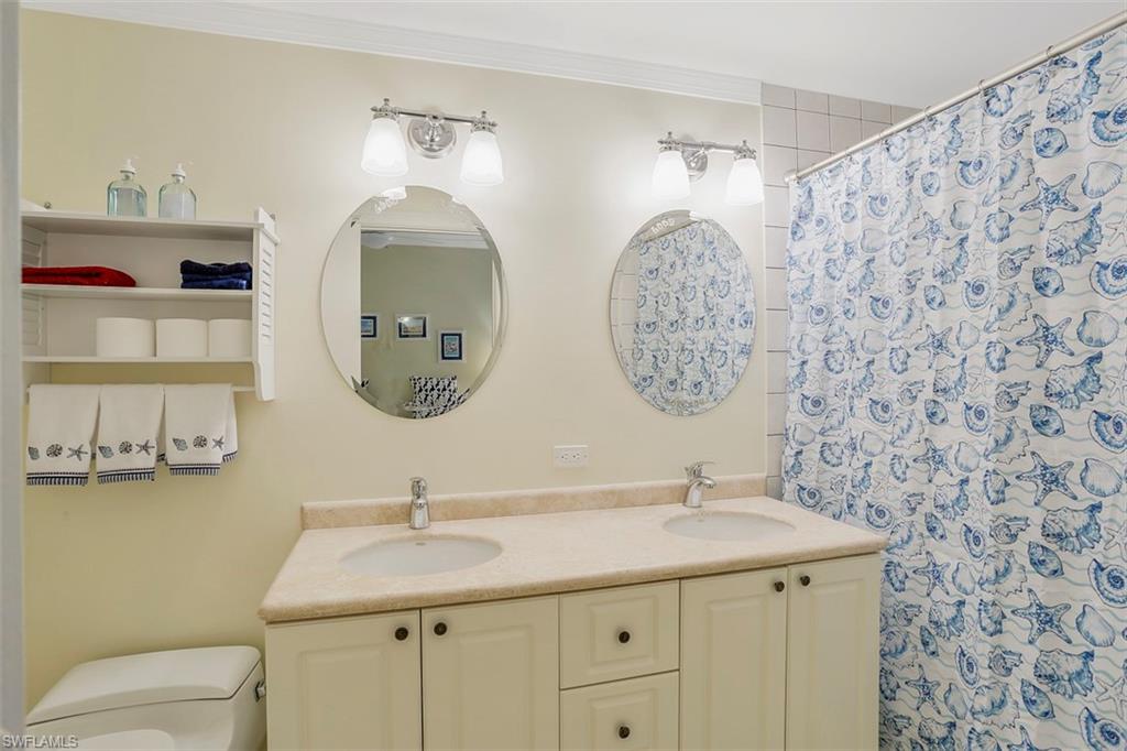 623 La Peninsula Boulevard, Unit 623 Naples, FL 34113 - Photo 23 of 27 a bathroom with a toilet sink and mirror