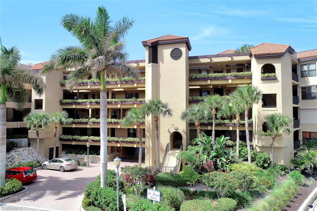 623 La Peninsula Boulevard, Unit 623 Naples, FL 34113 - Photo 3 of 27 a front view of a building with a garden