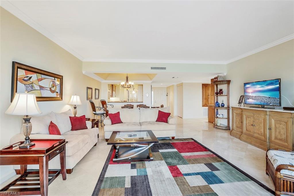 623 La Peninsula Boulevard, Unit 623 Naples, FL 34113 - Photo 6 of 27 a living room with furniture and a flat screen tv