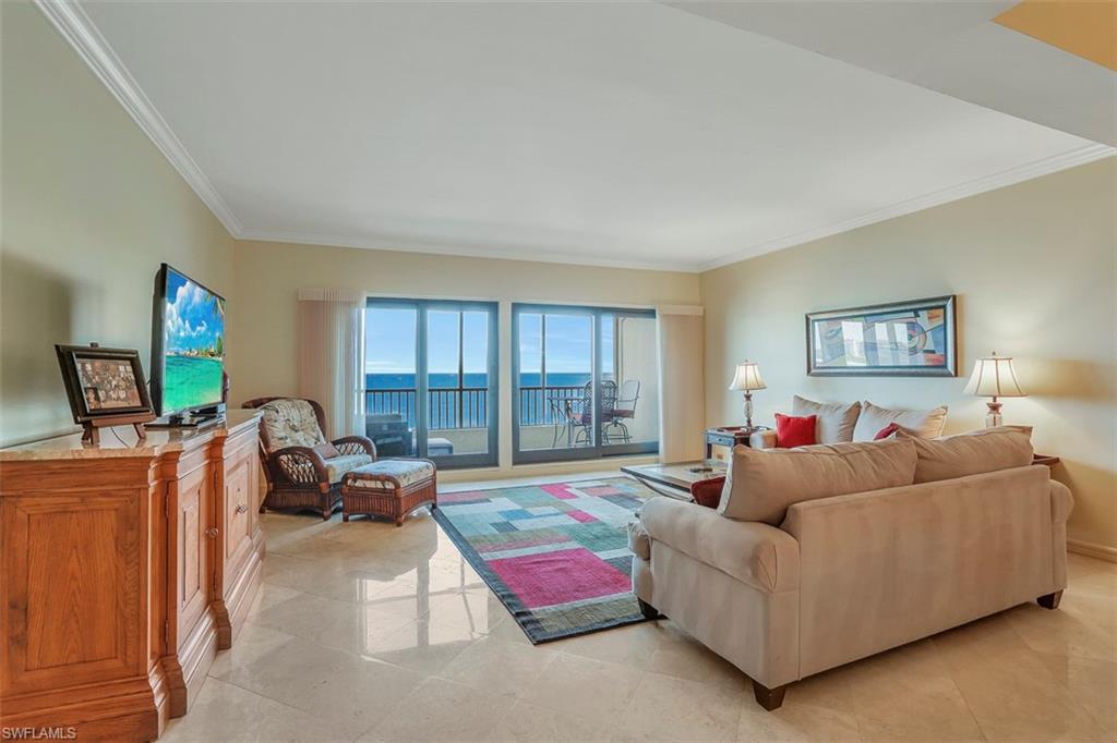 623 La Peninsula Boulevard, Unit 623 Naples, FL 34113 - Photo 10 of 27 a living room with furniture and a flat screen tv