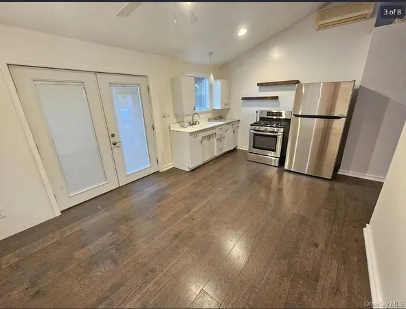 a view of kitchen with refrigerator stove and wooden floor