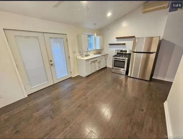 a view of kitchen with refrigerator stove and wooden floor