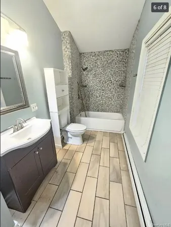 a bathroom with a sink a toilet a mirror and shower