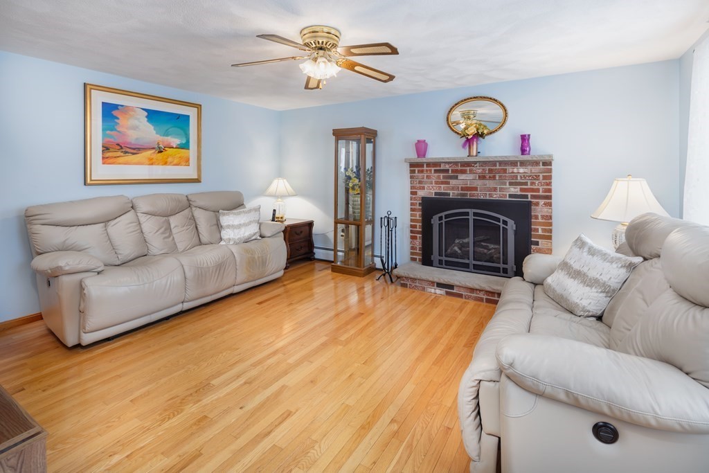 22 Stonehedge Circle Billerica, MA 01821 - Photo 2 of 30 a living room with furniture a clock and a fireplace