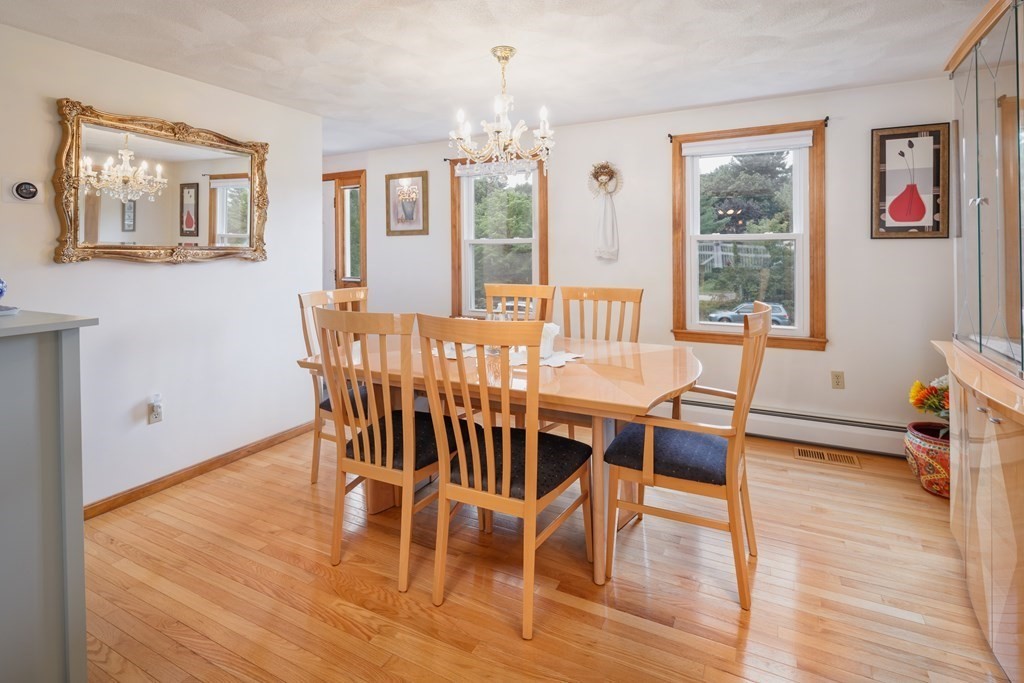 22 Stonehedge Circle Billerica, MA 01821 - Photo 8 of 30 a dining room with wooden floor a chandelier a glass table and chairs