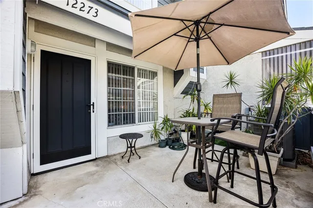 a view of a patio with a table and chairs under an umbrella