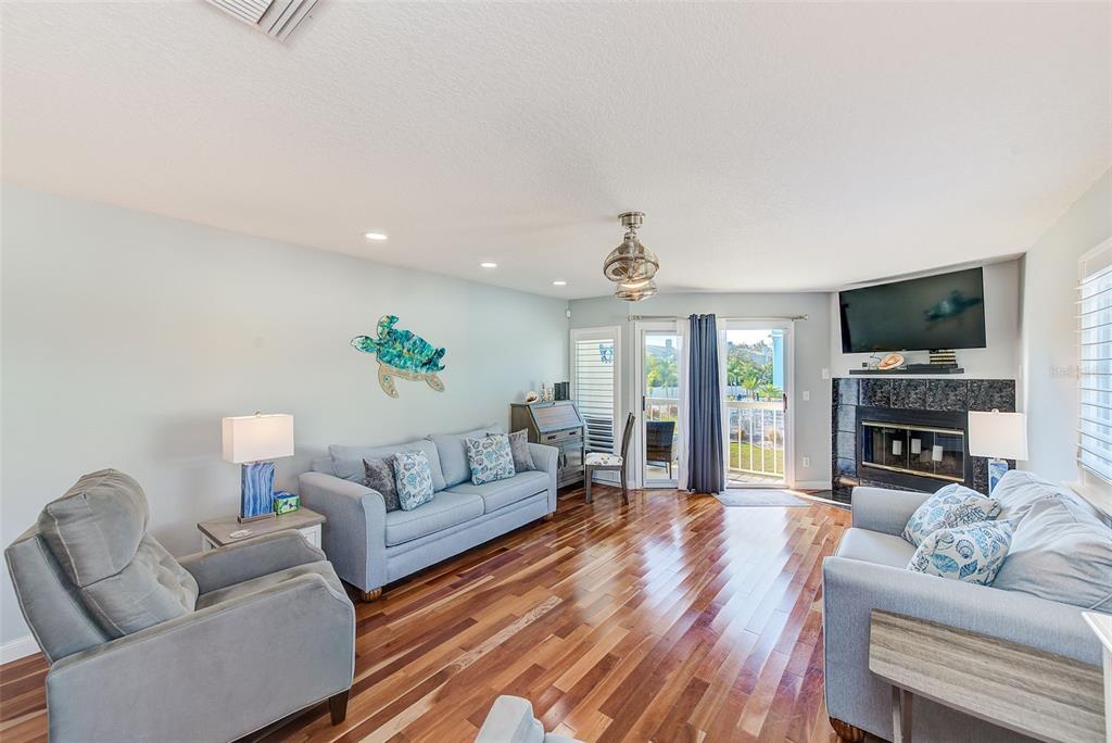 205 Marcdale Boulevard Indian Rocks Beach, FL 33785 - Photo 13 of 59 a living room with fireplace furniture and a flat screen tv