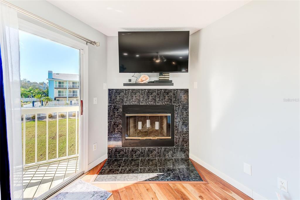 205 Marcdale Boulevard Indian Rocks Beach, FL 33785 - Photo 16 of 59 a living room with a fireplace and a flat screen tv