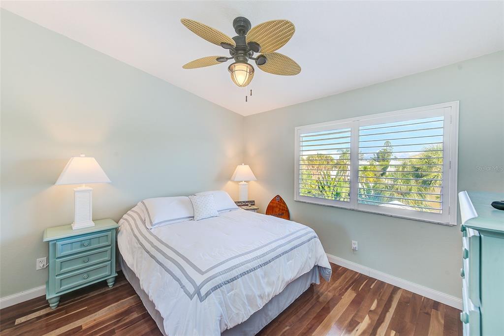 205 Marcdale Boulevard Indian Rocks Beach, FL 33785 - Photo 19 of 59 a bedroom with a bed and a chandelier