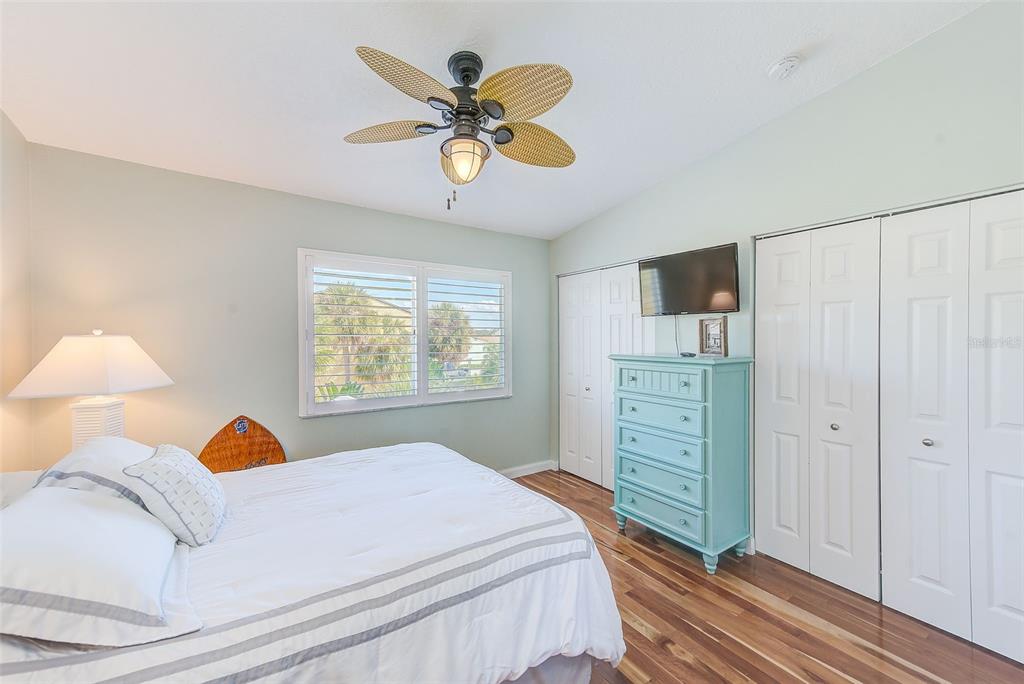 205 Marcdale Boulevard Indian Rocks Beach, FL 33785 - Photo 20 of 59 a bedroom with a bed and a chandelier