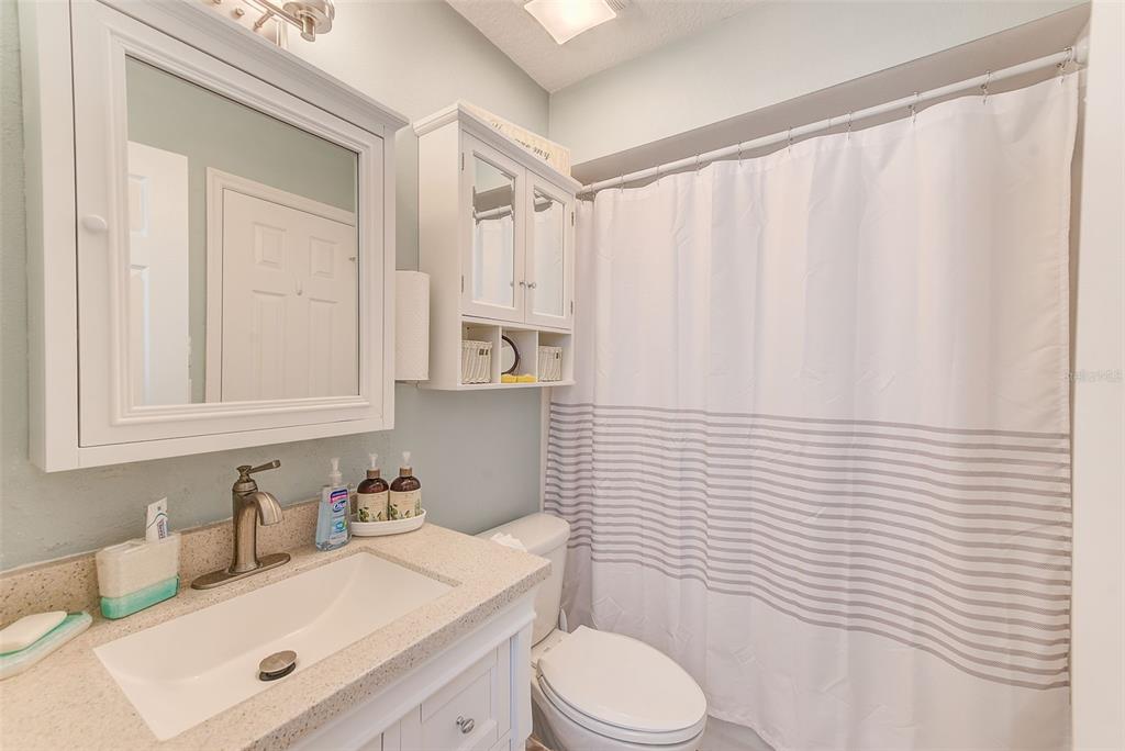 205 Marcdale Boulevard Indian Rocks Beach, FL 33785 - Photo 25 of 59 a bathroom with a sink a toilet and shower curtain