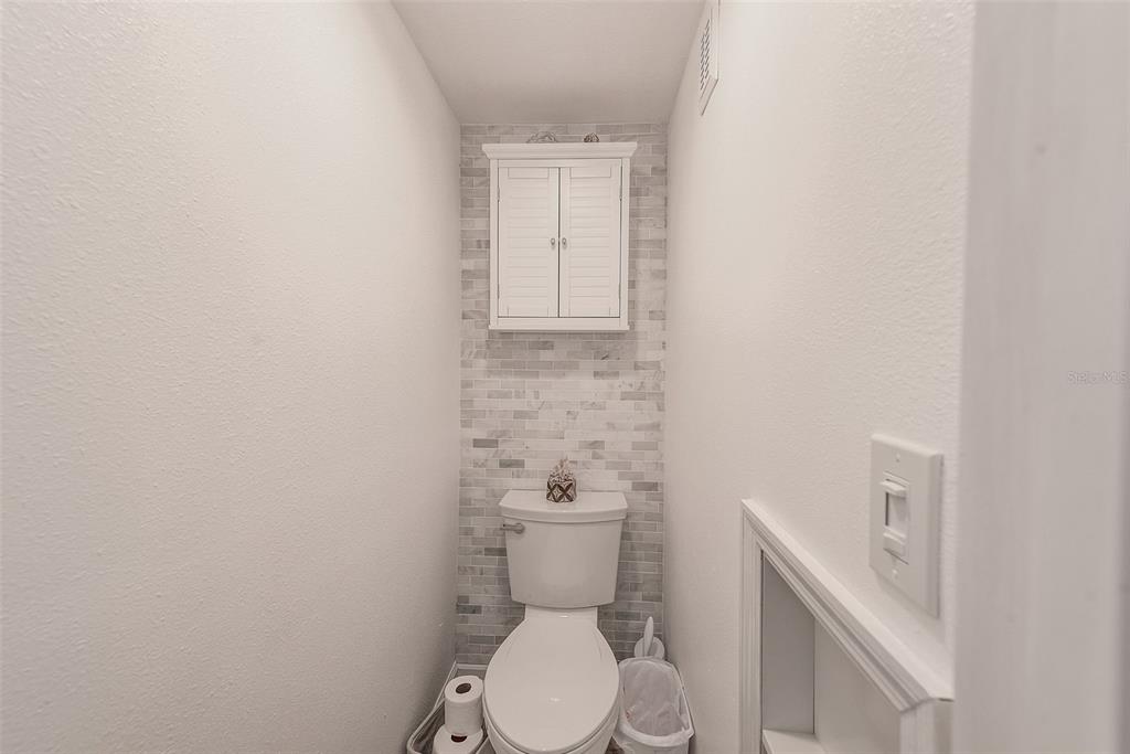 205 Marcdale Boulevard Indian Rocks Beach, FL 33785 - Photo 31 of 59 a white toilet sitting next to a white sink and vanity