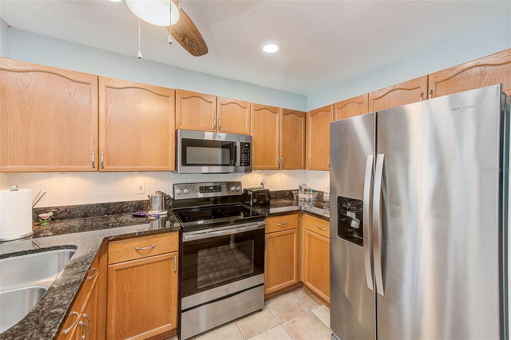 205 Marcdale Boulevard Indian Rocks Beach, FL 33785 - Photo 6 of 59 a kitchen with stainless steel appliances granite countertop a refrigerator a stove top oven a sink and dishwasher