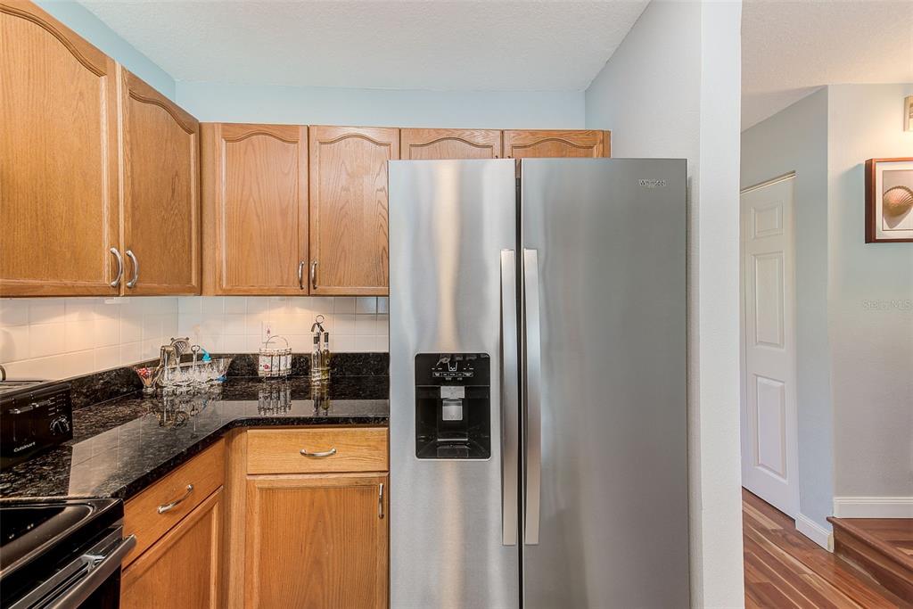 205 Marcdale Boulevard Indian Rocks Beach, FL 33785 - Photo 7 of 59 a kitchen with stainless steel appliances granite countertop a refrigerator and a stove top oven