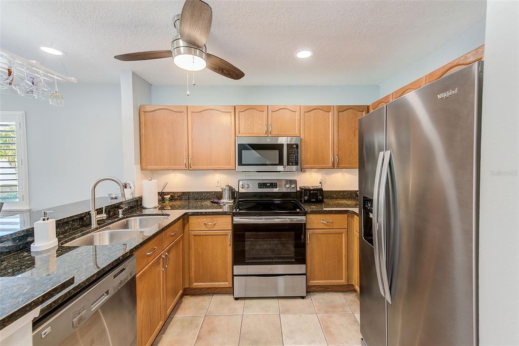 205 Marcdale Boulevard Indian Rocks Beach, FL 33785 - Photo 8 of 59 a kitchen with stainless steel appliances granite countertop a stove a refrigerator and a sink