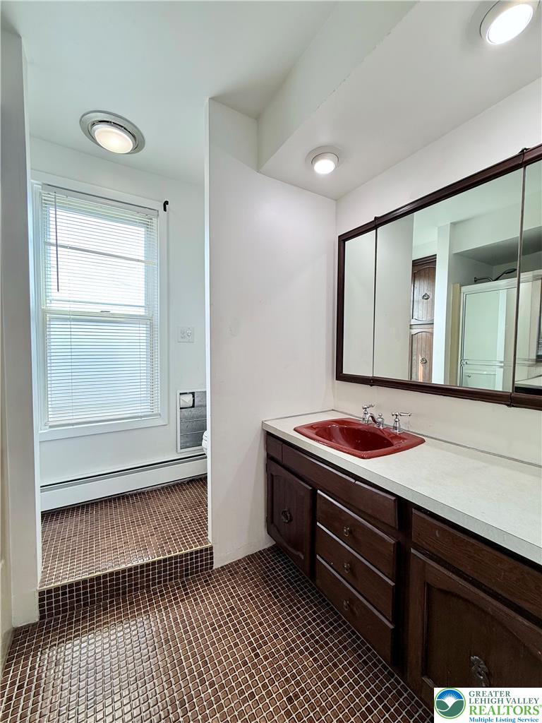5540 Main Street Whitehall, PA 18052 - Photo 22 of 53 A well-lit vanity with a vibrant red sink complements the classic tile flooring.