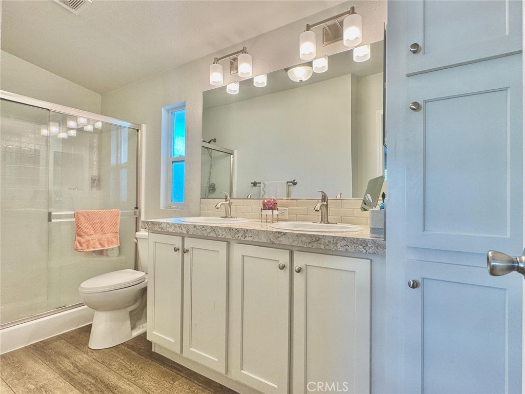 16600 Orange Avenue, Unit 130 Paramount, CA 90723 - Photo 13 of 31 a bathroom with a granite countertop sink toilet a mirror and a shower