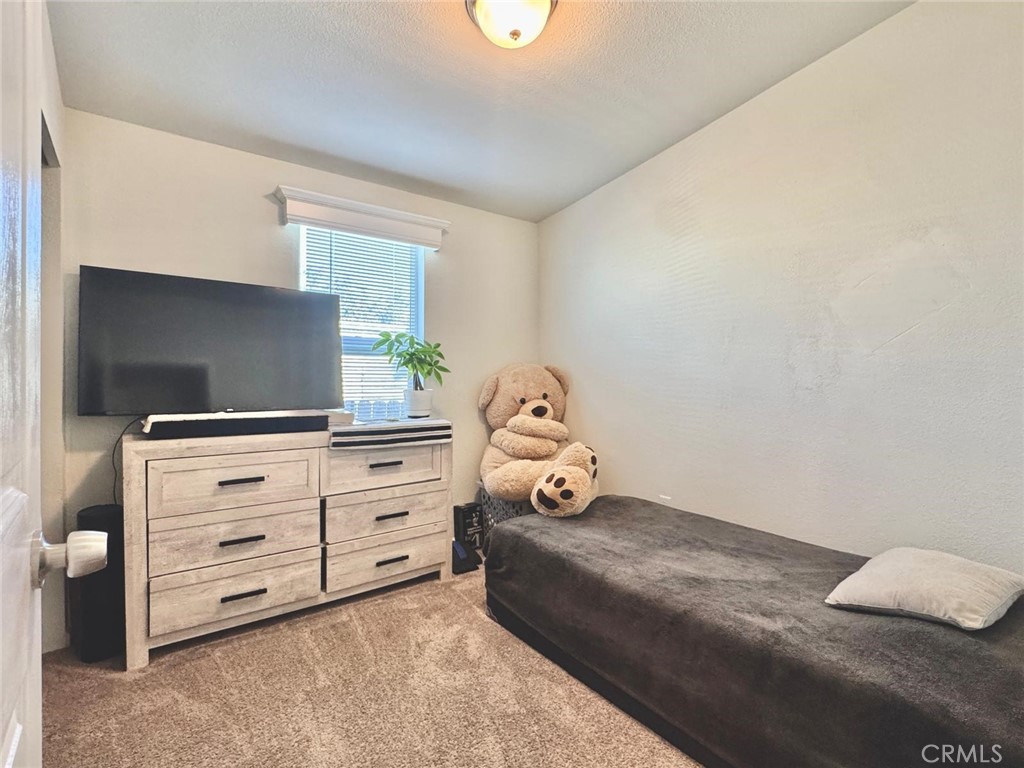 16600 Orange Avenue, Unit 130 Paramount, CA 90723 - Photo 14 of 31 a bedroom with a bed and a flat screen tv