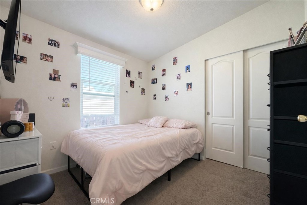 16600 Orange Avenue, Unit 130 Paramount, CA 90723 - Photo 18 of 31 a bedroom with a bed and a tv on the dresser