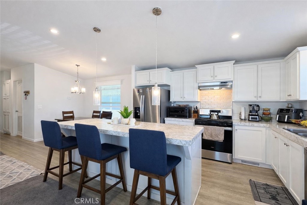 16600 Orange Avenue, Unit 130 Paramount, CA 90723 - Photo 9 of 31 a kitchen with a dining table chairs and refrigerator
