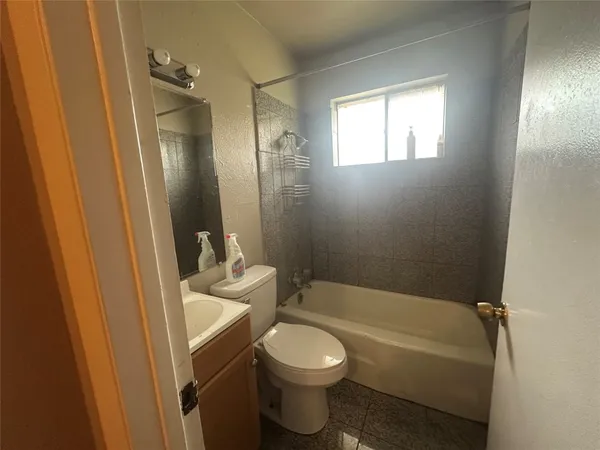 a bathroom with a granite countertop toilet sink and mirror