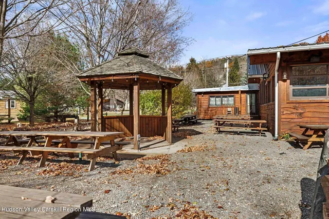 a view of a patio with table and chairs a barbeque with wooden floor and fence