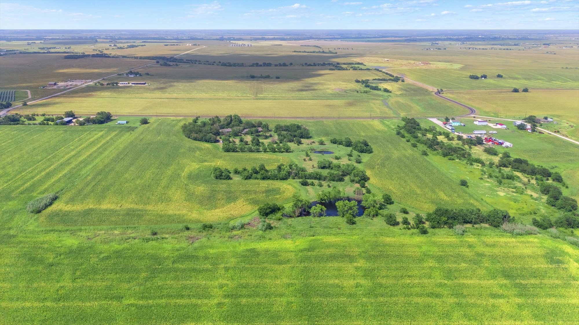 14201 Lund - Carlson Road Coupland, TX 78615 - Photo 24 of 40 Vast green fields stretch under a clear sky, offering a serene, rural escape.