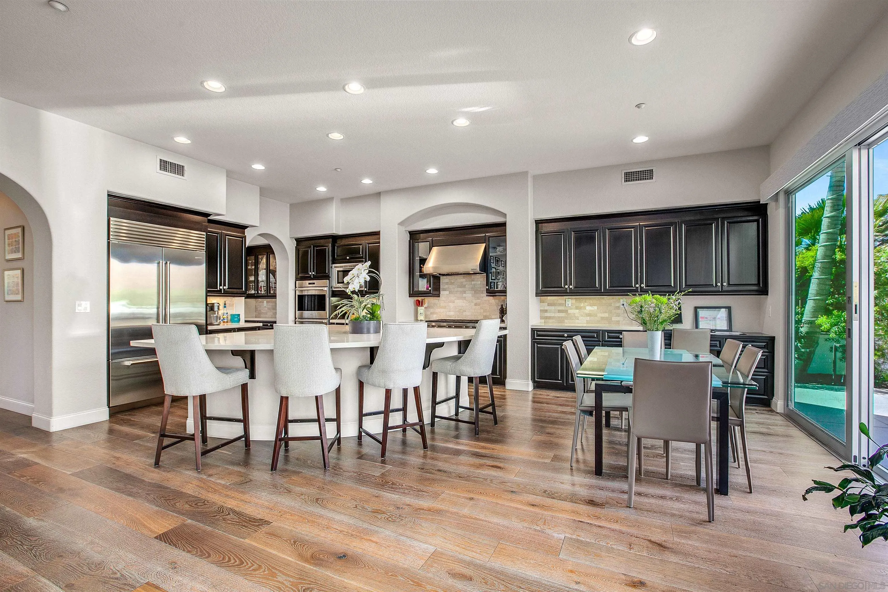 1460 Ravean Court Encinitas, CA 92024 - Photo 12 of 48 a kitchen with stainless steel appliances dining table wooden floor and a view of kitchen