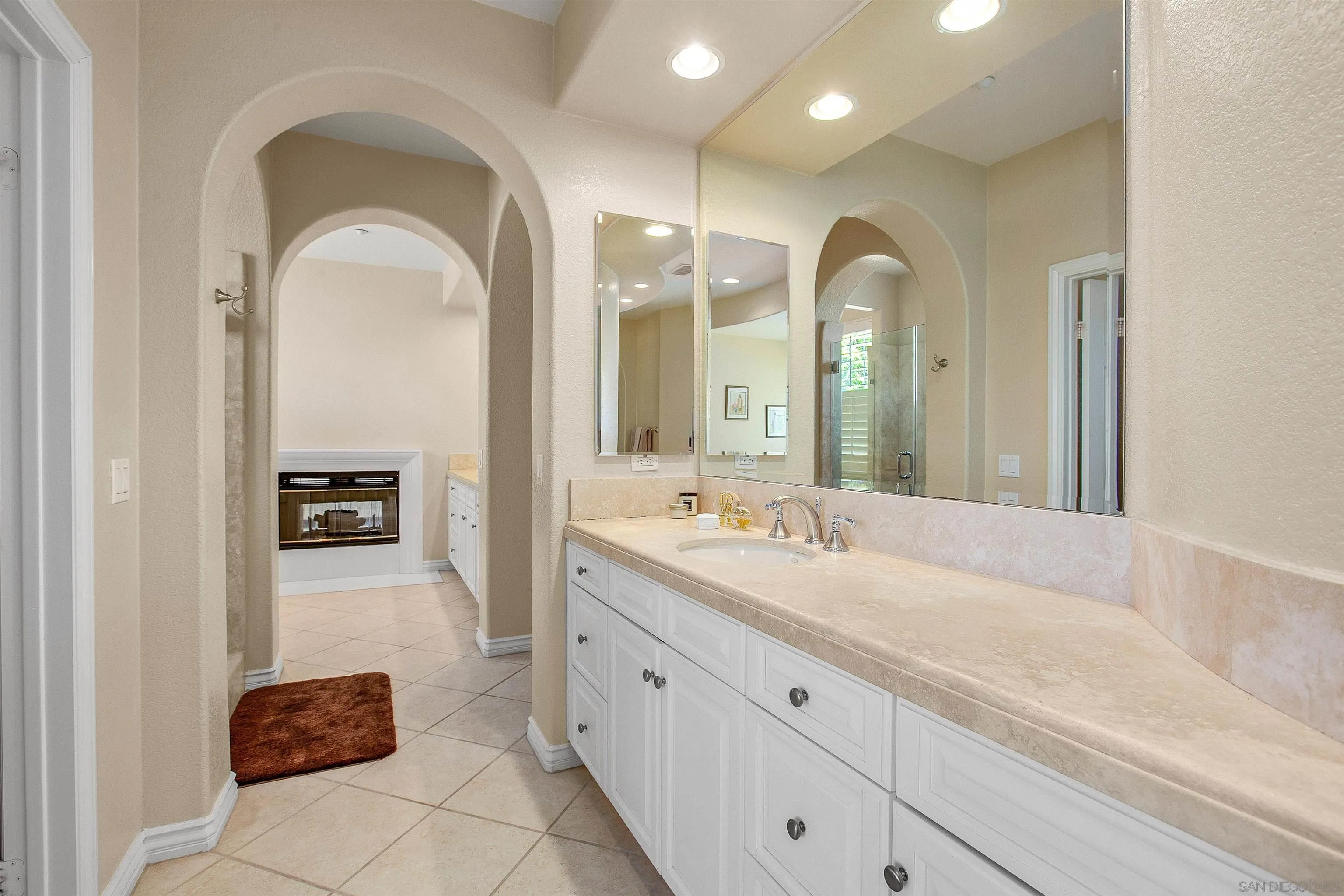 1460 Ravean Court Encinitas, CA 92024 - Photo 33 of 48 a spacious bathroom with a granite countertop sink a mirror and shower