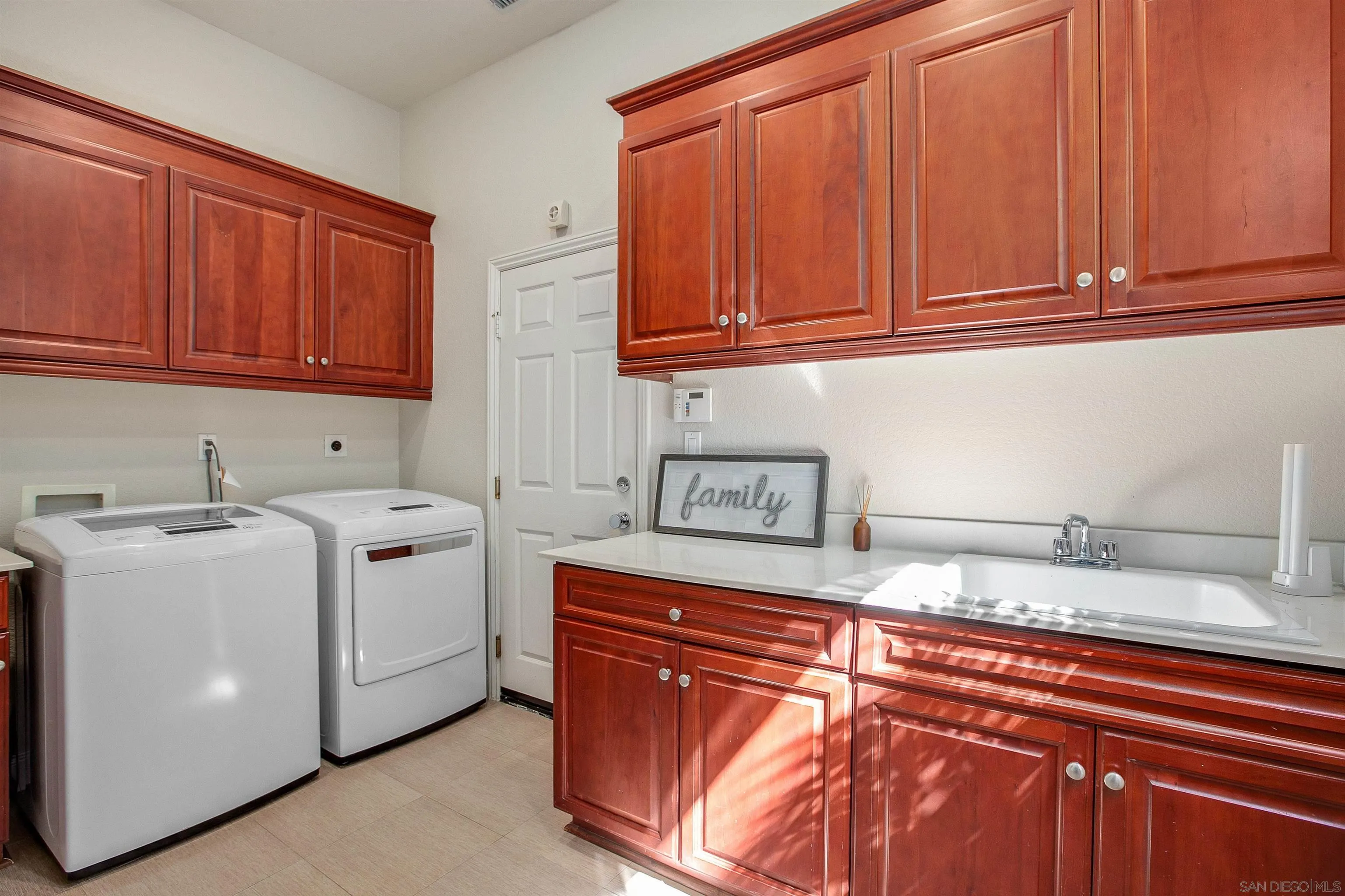 1460 Ravean Court Encinitas, CA 92024 - Photo 38 of 48 a utility room with stainless steel appliances granite countertop a sink dishwasher stove and cabinets with wooden floor