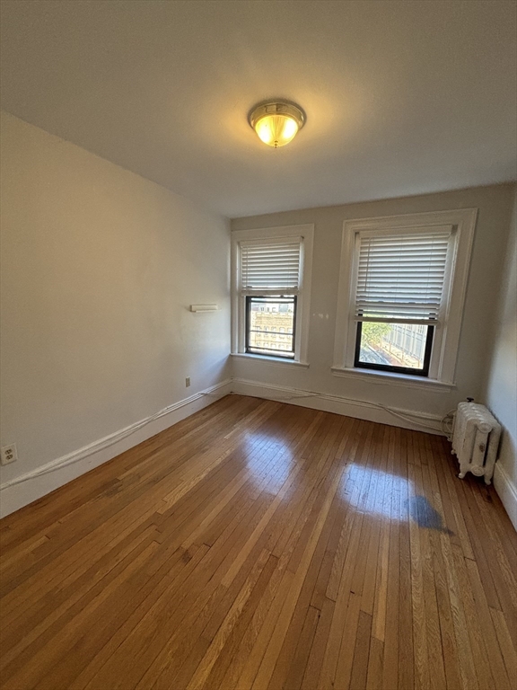 448 Park Drive, Unit 17 Boston, MA 02215 - Photo 3 of 11 an empty room with wooden floor and windows
