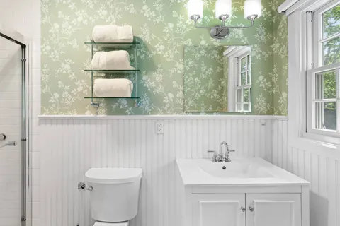 a bathroom with a toilet sink and mirror