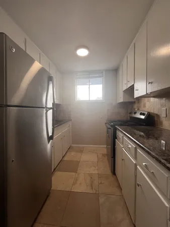 a kitchen with a refrigerator a stove a microwave and cabinets