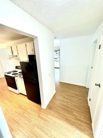 a view of a hallway with wooden floor and staircase
