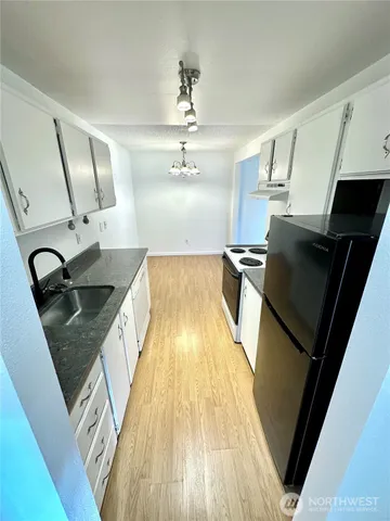 a kitchen with granite countertop a sink and a stove