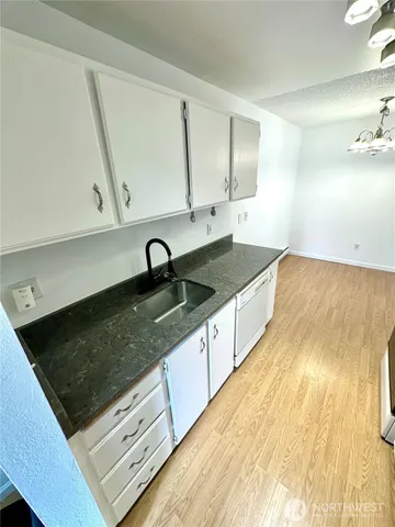 a kitchen with stainless steel appliances granite countertop a sink a stove and a microwave