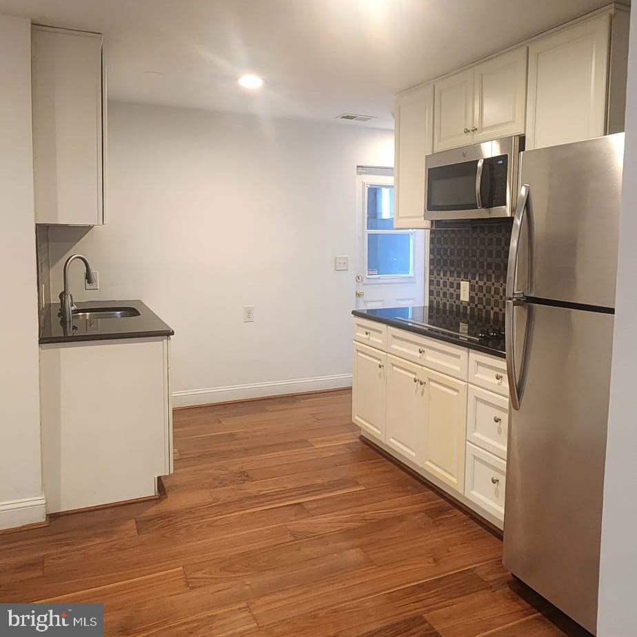 1134 12th Street Laurel, MD 20707 - Photo 1 of 13 a kitchen with a refrigerator sink and cabinets