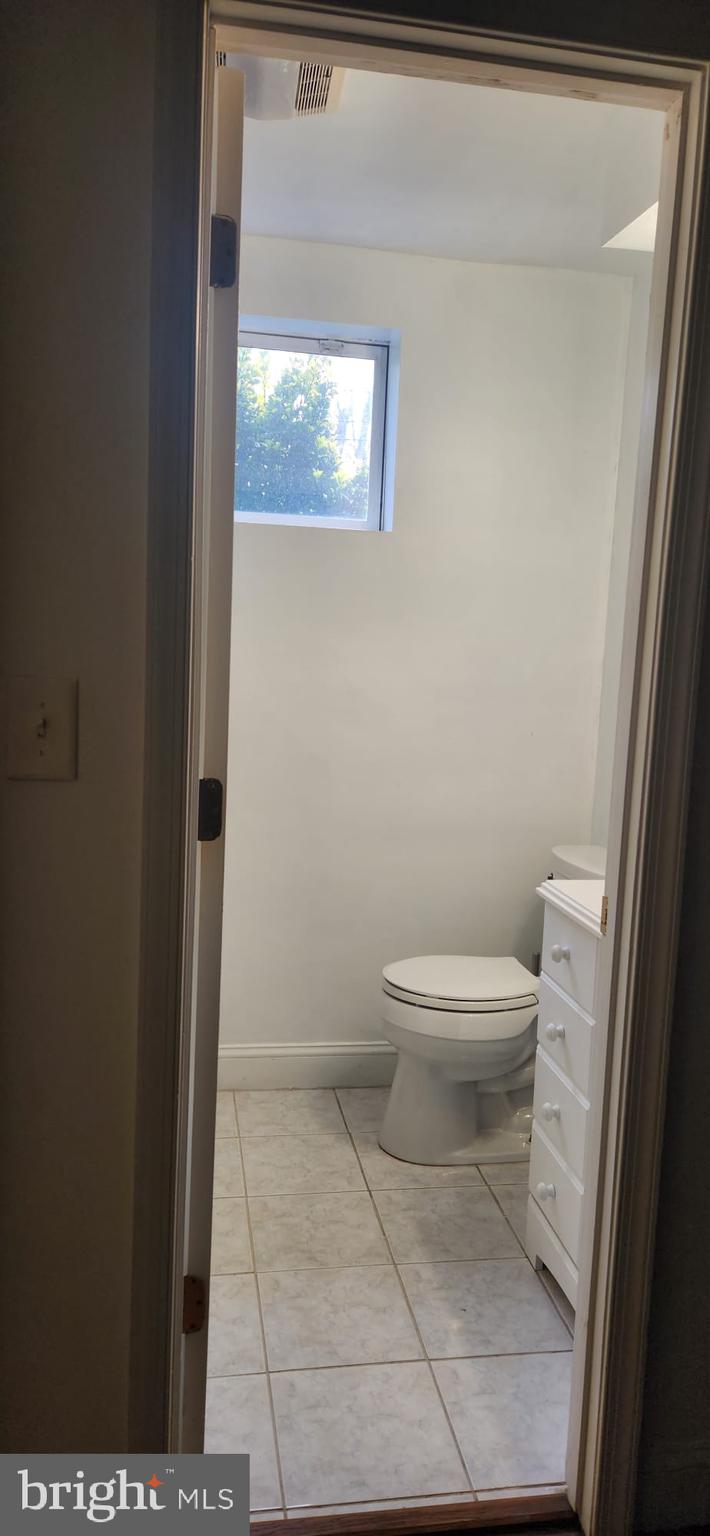 1134 12th Street Laurel, MD 20707 - Photo 12 of 13 a white toilet sitting next to a small window