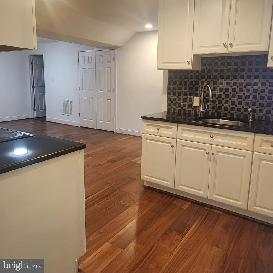 1134 12th Street Laurel, MD 20707 - Photo 9 of 13 a kitchen with cabinets and wooden floor