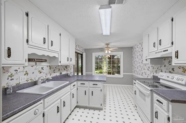 a kitchen with stainless steel appliances a sink stove and cabinets