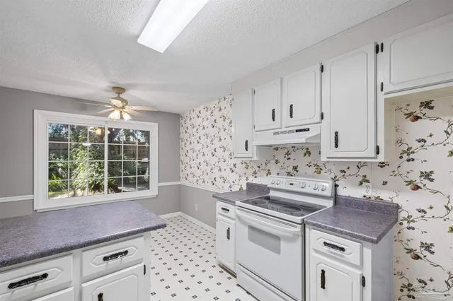 a kitchen with stainless steel appliances white cabinets and a stove top oven